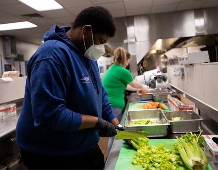 Student participating in meal prep for food bank